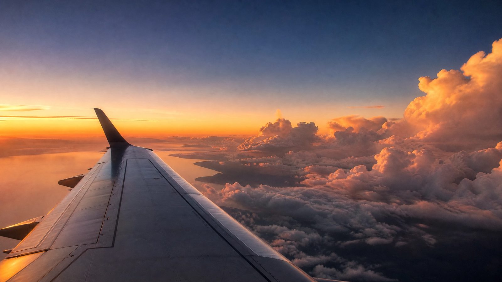 Ala de avión sobre las nubes al atardecer